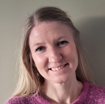 En kvinne som smiler til kameraet