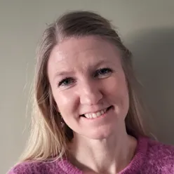 En kvinne som smiler til kameraet