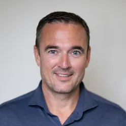 Portrettfoto av en mann som smiler til kameraet